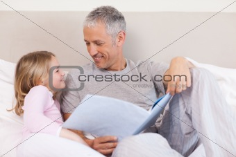 Happy father reading a story to his daughter