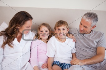 Smiling family lying on a bed