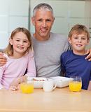 Portrait of a father posing with his children in the morning