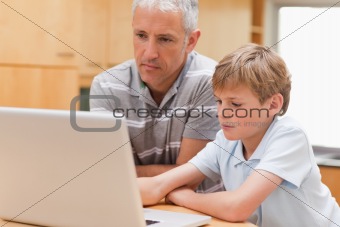 Boy and his father using a laptop