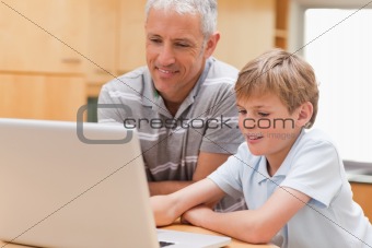 Boy and his father using a notebook