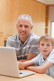Portrait of a boy and his father using a laptop