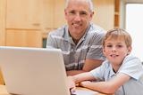 Young boy and his father using a laptop