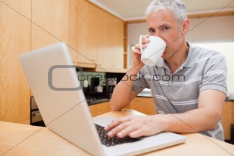 Man using a notebook while drinking coffee