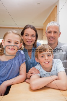 Portrait of a family posing in a kitchen