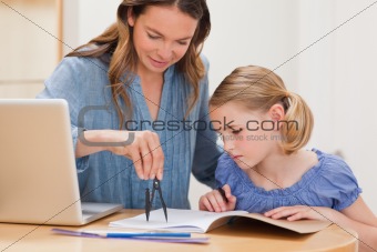 Mother helping her daughter doing her homework