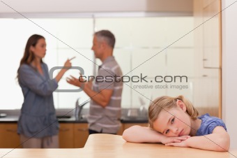 Sad little girl listening her parents having an argument