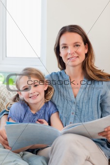 Portrait of a mother reading a book to her daughter
