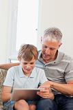 Portrait of a happy father and his son using a tablet computer
