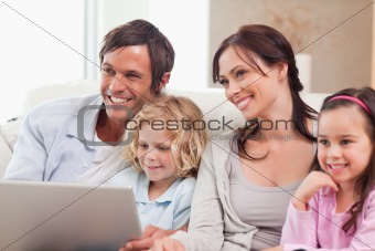 Delighted family using a notebook