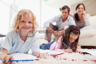 Children drawing while their parents are in the background