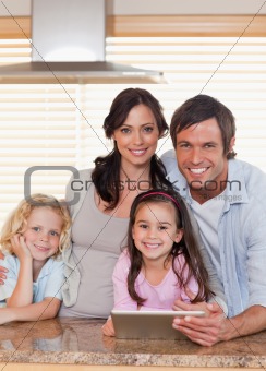 Portrait of a smiling family using a tablet computer together