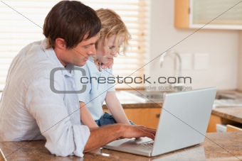 Boy and his father using a laptop together
