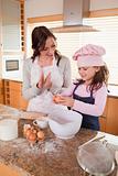 Portrait of a mother teaching her daughter how to bake