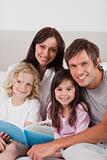 Portrait of a happy family reading a book