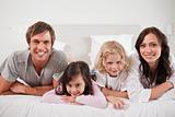 Smiling family lying in a bed