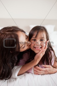 Portrait of a mother kissing her daughter
