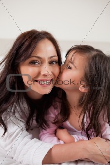 Portrait of a girl kissing her mother