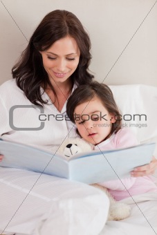 Portrait of a mother reading a story to her daughter