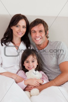 Portrait of parents posing with their daughter