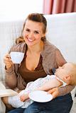 Happy mother resting while baby sleep by having tea and reading book
