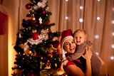Portrait of smiling young mother with beautiful baby  near Christmas tree