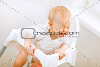 Crying baby in baby chair
