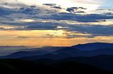 Cloudy sunset over emerald mountain ridges