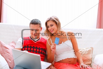 Happy young pregnant woman with husband making on-line purchases
