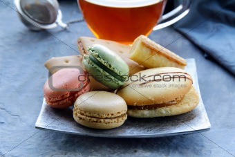 traditional french macarons with tea set on the background