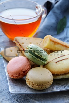 traditional french macarons with tea set on the background
