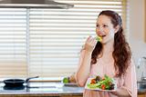 Girl eating some salad in the kitchen
