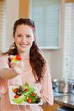 Smiling woman offering some salad