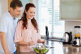 Couple with bowl of salad in the kitchen