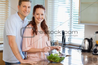 Couple with salad in the kitchen