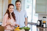 Couple in the kitchen preparing salad