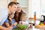 Family together with salad in the kitchen