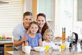 Family together with breakfast standing behind the kitchen counter
