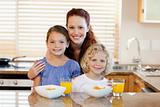 Mother with children and breakfast in the kitchen