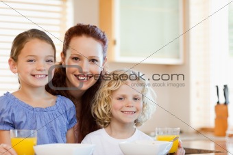 Smiling mother with her children in the kitchen