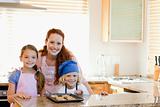Mother with children and cookies in the kitchen