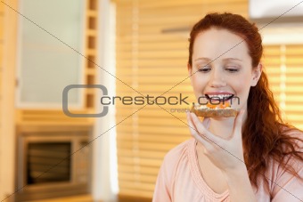 Woman eating a slice of bread in the kitchen