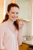 Smiling woman holding slice of bread