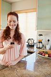 Woman writing text message in the kitchen