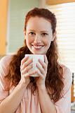 Smiling woman with her cup of coffee