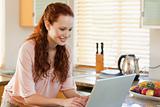 Woman with her laptop in the kitchen