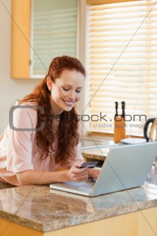 Woman shopping online in the kitchen