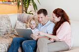 Family using laptop on the sofa