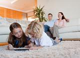 Children using tablet on the carpet