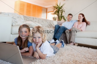 Siblings with notebook on the floor
